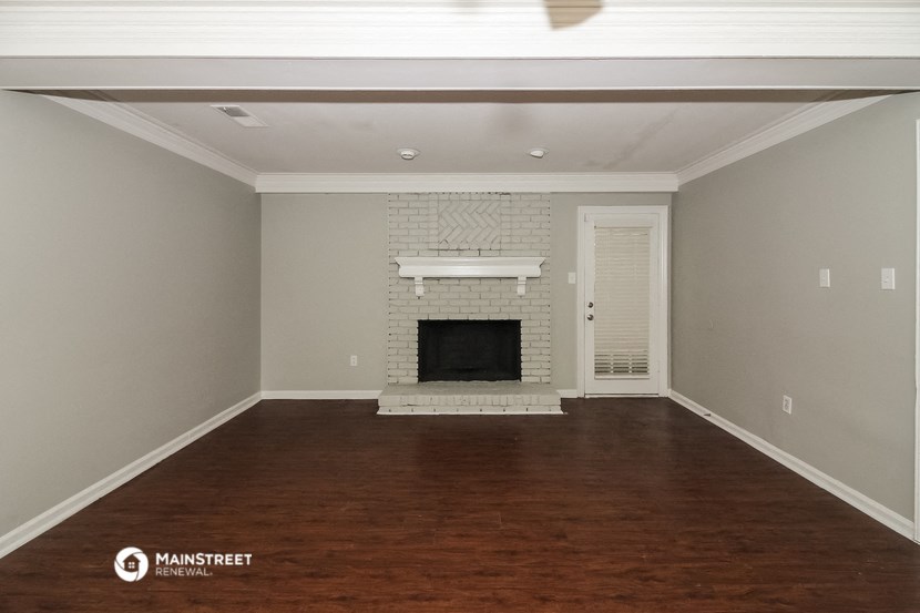 a living room with a fireplace and wooden floors
