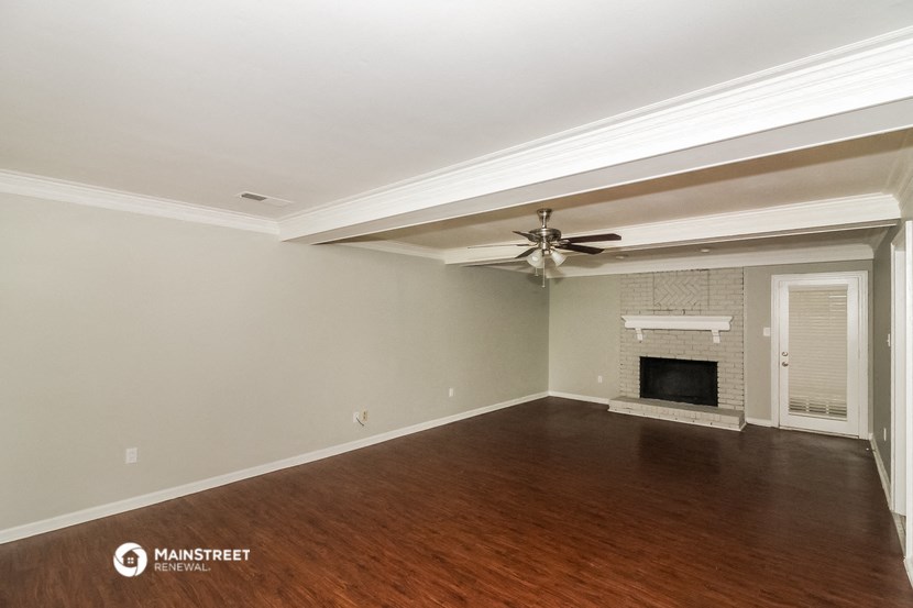 a living room with a ceiling fan and a fireplace