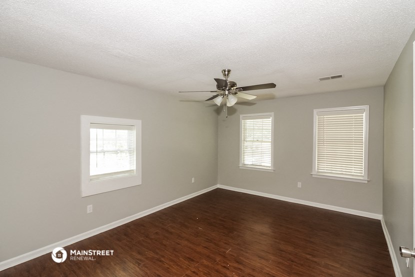 the bedroom with hardwood flooring and a ceiling fan