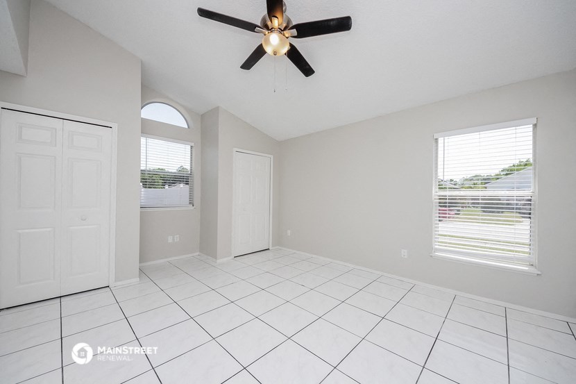 an empty living room with a ceiling fan