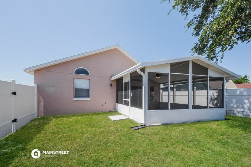 the exterior of a pink house with a lawn and a porch