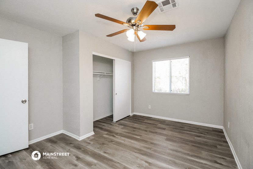 an empty room with a ceiling fan and a closet