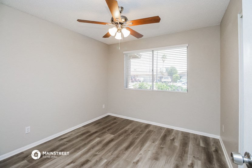 an empty room with a ceiling fan and a window