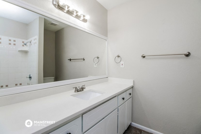 a white bathroom with a sink and a mirror