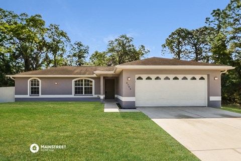 a house with a lawn and a white garage door