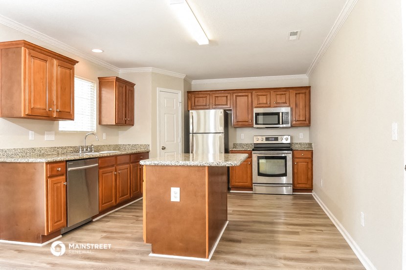 a kitchen with wooden cabinets and stainless steel appliances