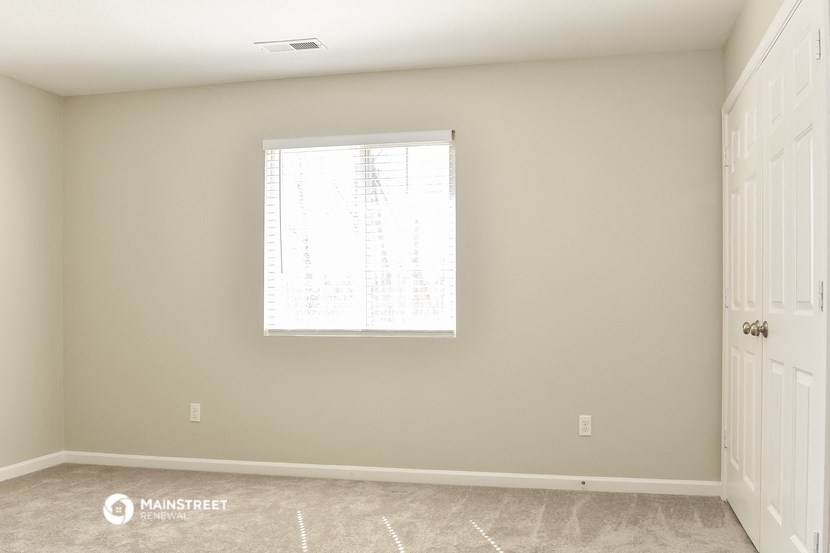 an empty room with a window and a door