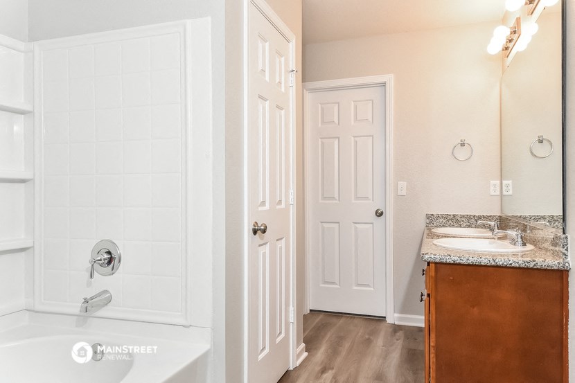 a bathroom with a tub and a sink and a mirror