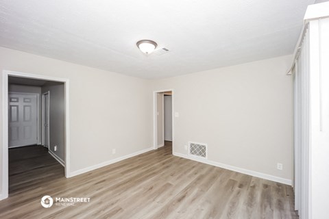 the spacious living room and dining room of an apartment