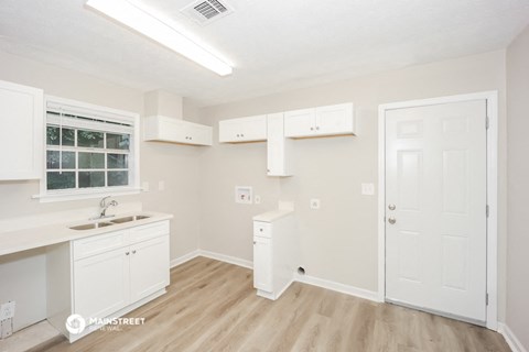 a kitchen with white cabinets and a sink and a window