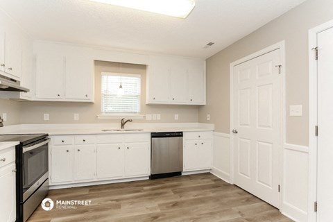 a kitchen with white cabinets and a dishwasher and a sink