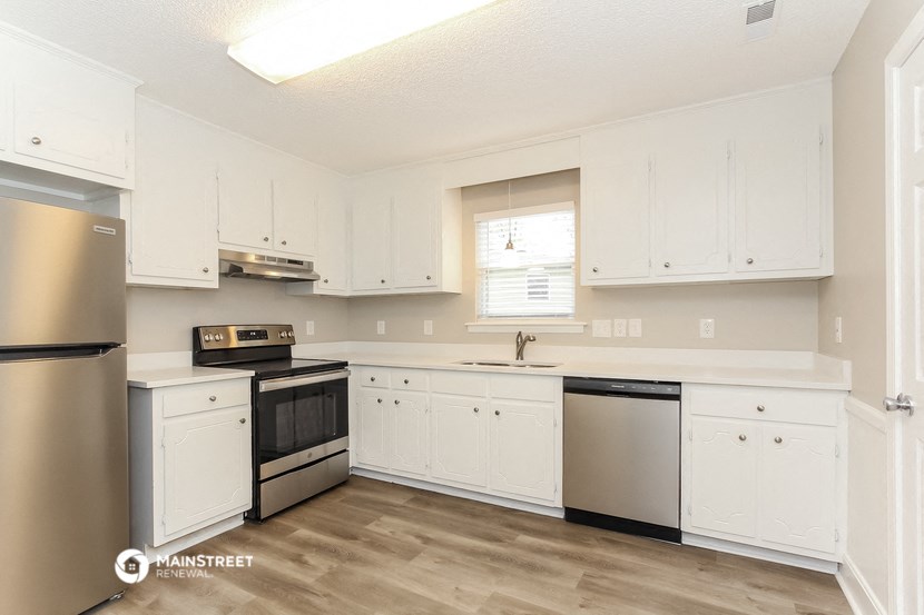 a kitchen with white cabinets and stainless steel appliances