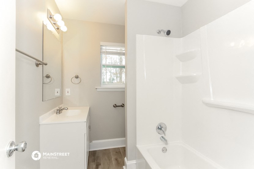 a bathroom with a shower and a sink and a mirror