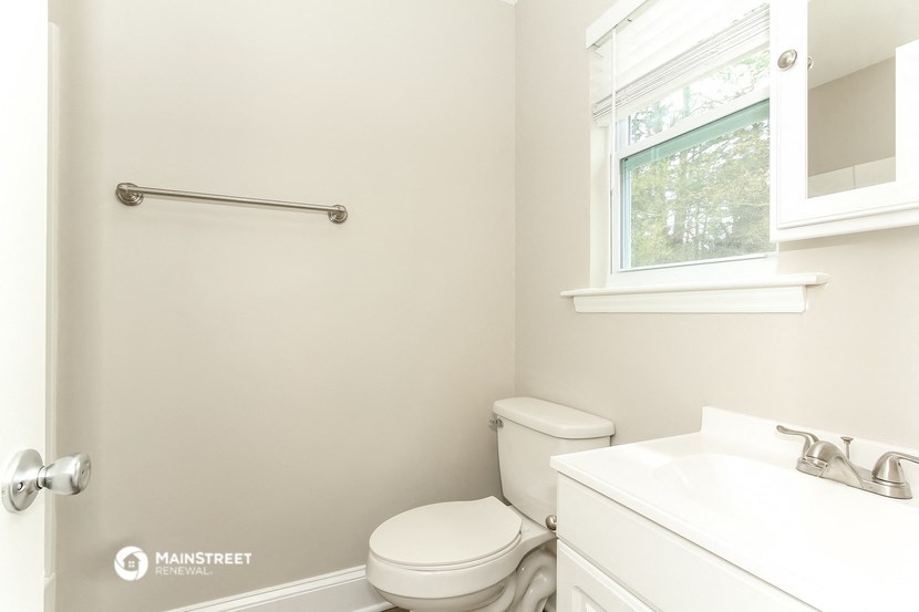 a bathroom with a toilet and a sink and a window