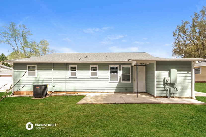 a white house with a yard and a backdoor