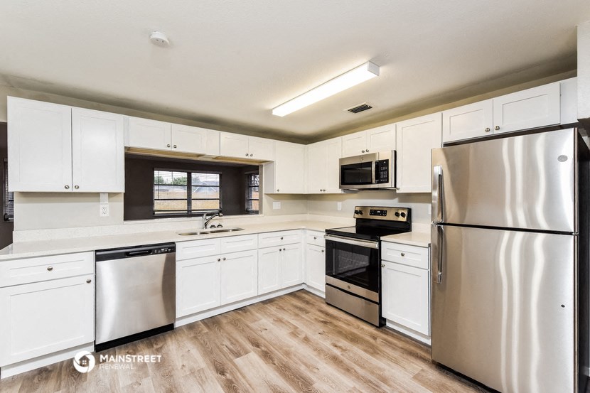 a kitchen with white cabinets and stainless steel appliances