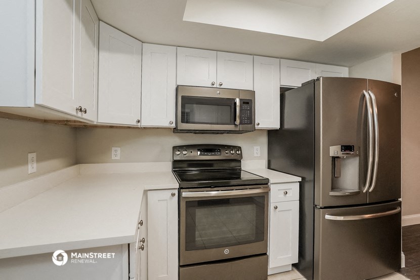 a kitchen with stainless steel appliances and white cabinets
