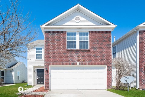 a white garage door in front of a brick house