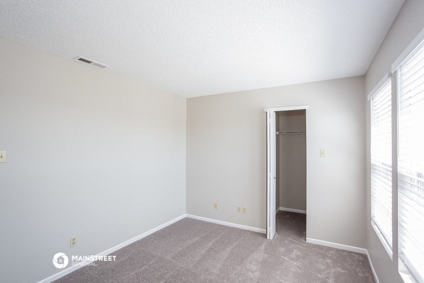 the living room of an apartment with a door to the closet