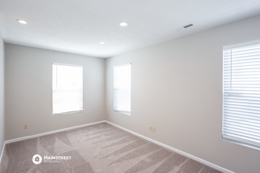 the living room of a new home with white walls and windows