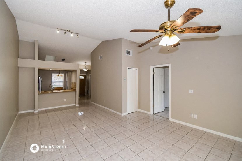 the living room and dining room with ceiling fan and tiled floor