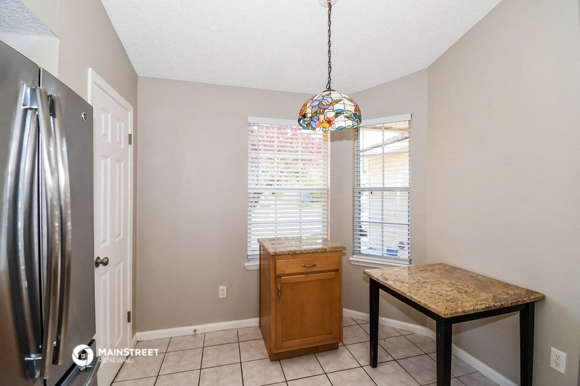 a kitchen with a sink and a refrigerator and a table