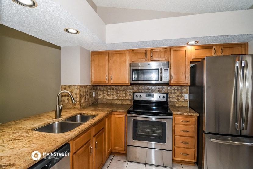 a kitchen with stainless steel appliances and wooden cabinets