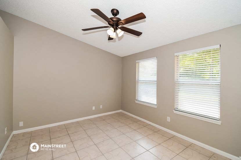 the living room has a ceiling fan and a tiled floor