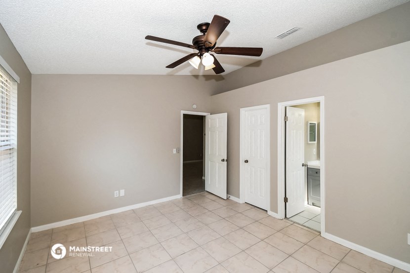 the living room has a ceiling fan and a tiled floor