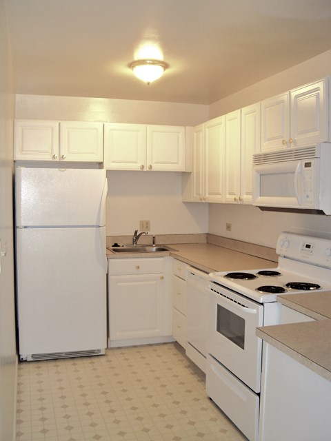 a kitchen with white appliances and white cabinets
