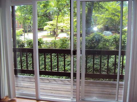 a balcony with a view of a yard and trees