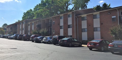a row of cars parked in front of a brick building