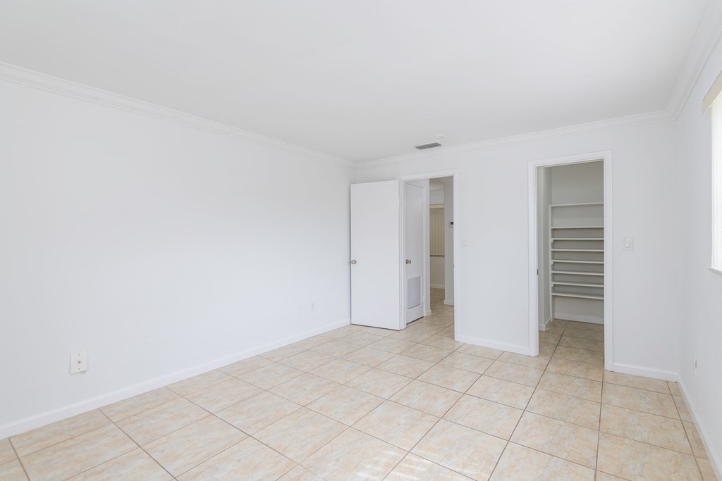 an empty living room with a tile floor and white walls