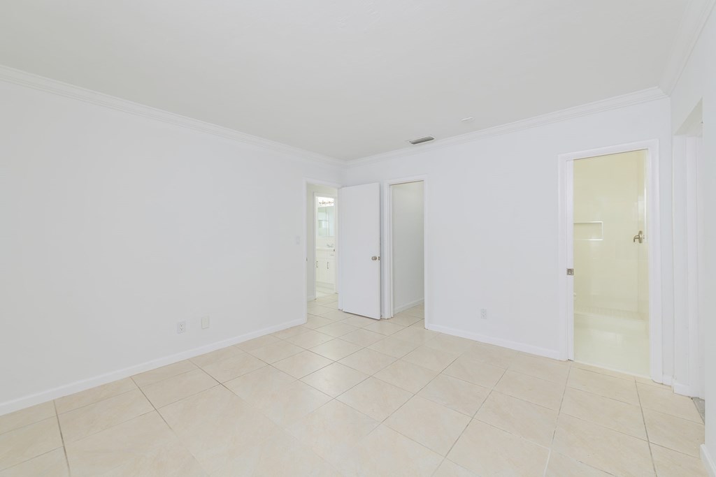 a living room with a tiled floor and white walls