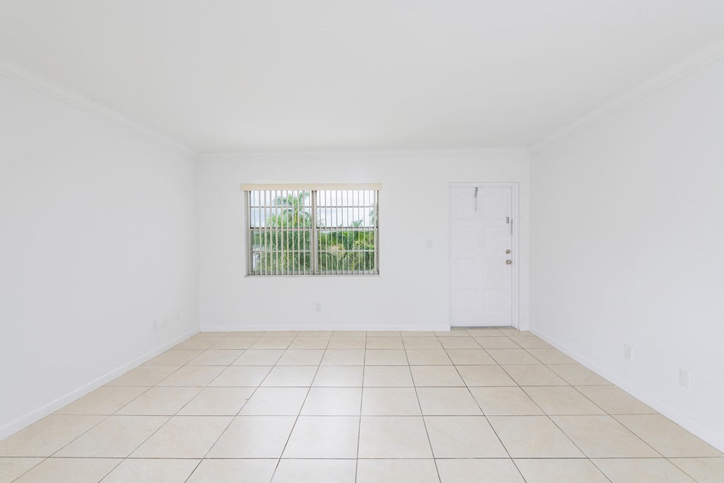 an empty living room with white walls and a window