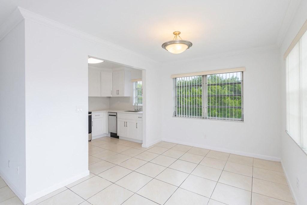 a kitchen with a large window and a tiled floor