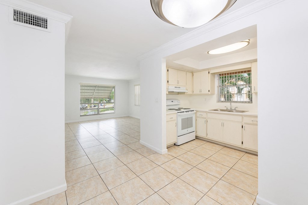 a large kitchen with white appliances and tiled floors