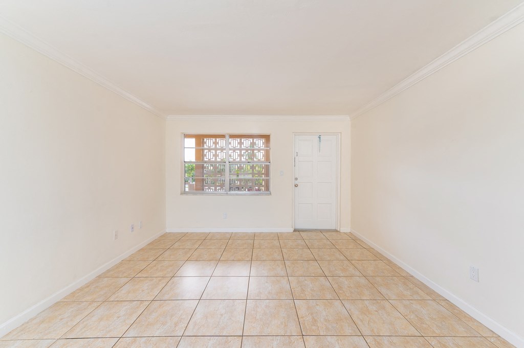 an empty living room with tile flooring and a window