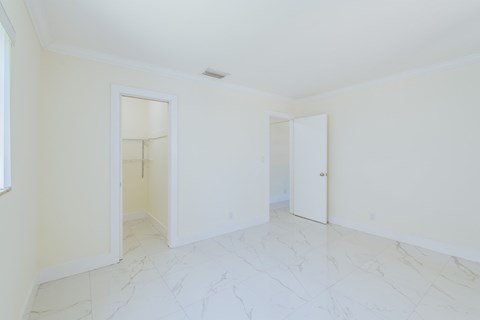 an empty living room with white walls and white marble floors
