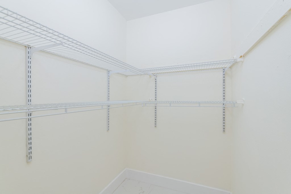 a room with white walls and shelves in a closet