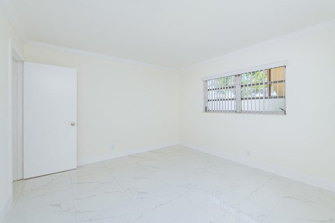 an empty room with a window and a door