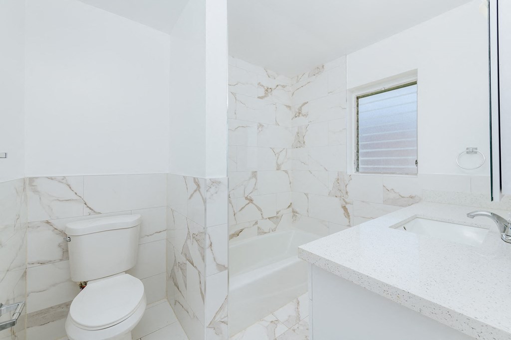 a white bathroom with a toilet and a sink