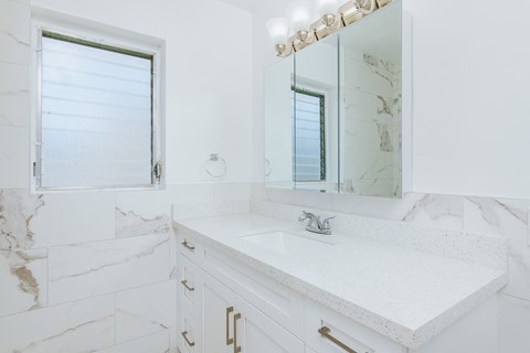 a white and marble bathroom with a sink and mirror