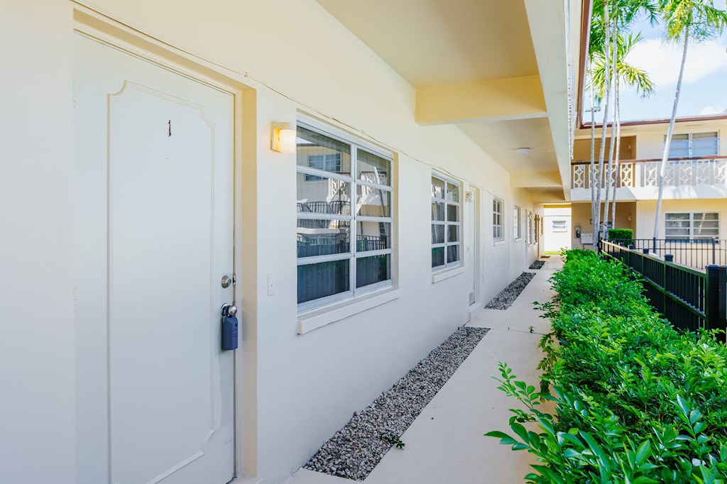 the doors to the building are open to the corridor with green plants