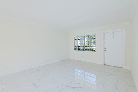 an empty living room with white walls and a window