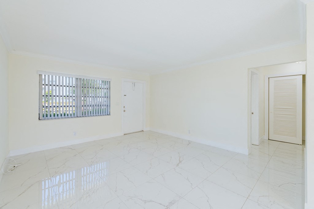 an empty living room with a window and a door