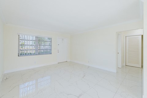 an empty living room with a window and a door