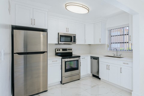 a kitchen with stainless steel appliances and white cabinets