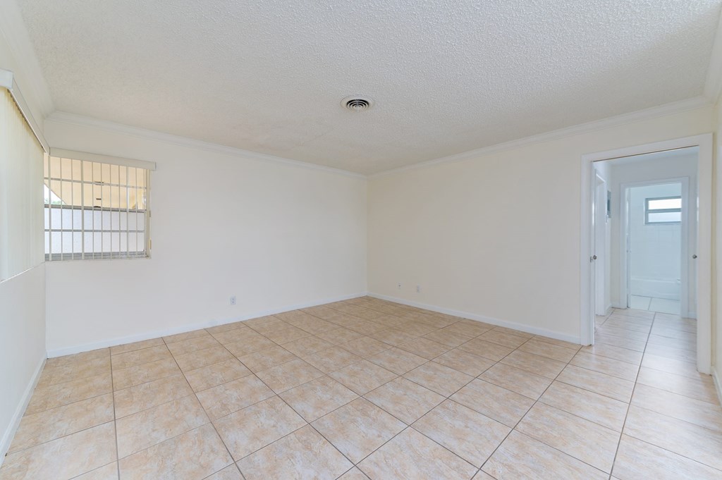 the living room and dining room of an empty house with tile flooring