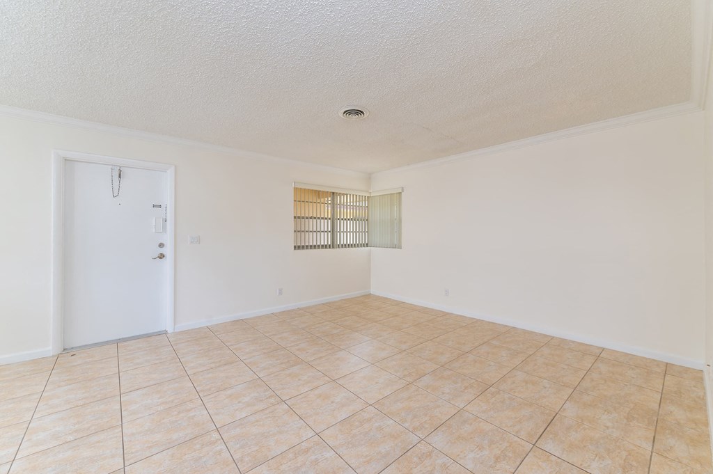 the living room and dining room of an empty home with tile flooring